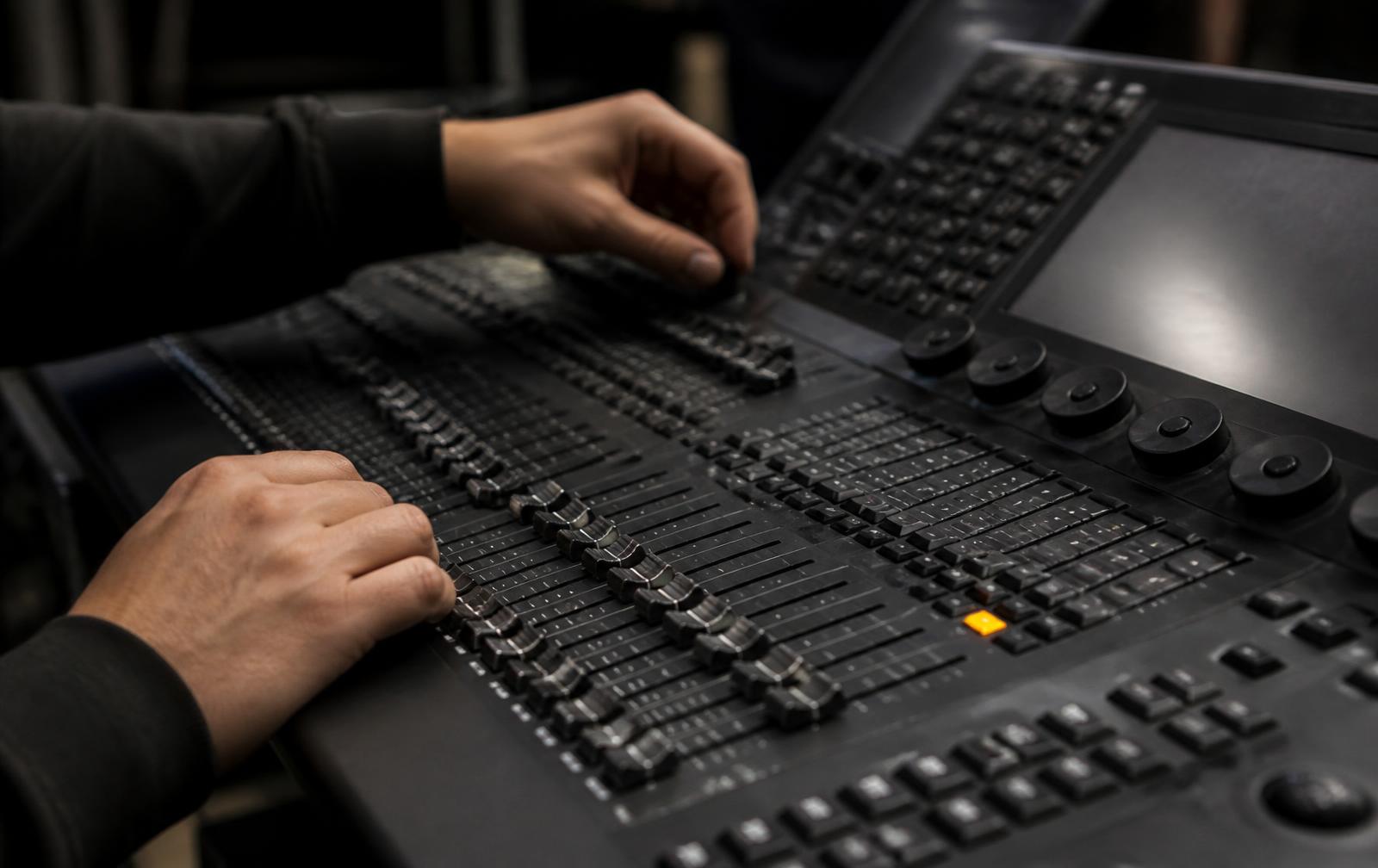 Technicien lumière aux commandes d’une console professionnelle